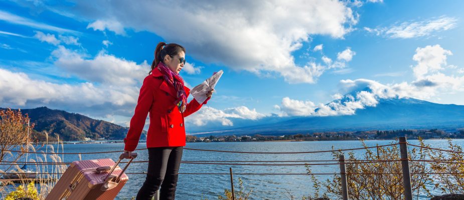 Tourist with baggage and map at Fuji mountain, Kawaguchiko in Japan.